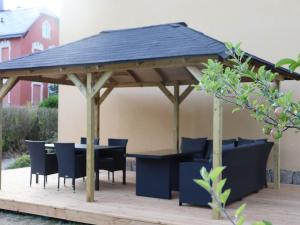 a wooden gazebo with a table and chairs at Heritage villa with home cinema sauna in Treuen