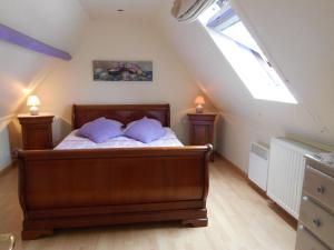 a bedroom with a bed with two pillows on it at Cosy house with private pool in Folleville in Sourdon
