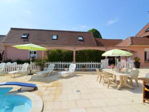 a patio with a table and chairs and a pool at Cosy house with private pool in Folleville in Sourdon