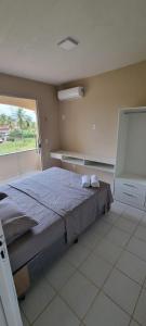 sypialnia z łóżkiem i dużym oknem w obiekcie Salinopolis- casa com piscina w mieście Salinópolis