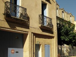 um edifício com duas varandas do lado em Old wine storehouse with terrace and garden em Puimisson