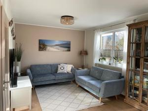 a living room with two blue couches and a window at Ostseeauszeit Blengow in Rerik