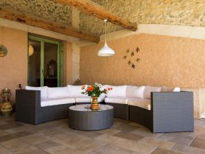 a living room with two couches and a table with flowers at Old wine storehouse with terrace and garden in Puimisson