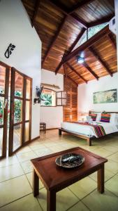 a living room with a bed and a coffee table at Hotel El Pequeño Gecko Verde in Sámara