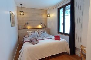 una camera da letto con un letto con due cuscini e una finestra di Les ateliers du Cucheron a Saint-Pierre-de-Chartreuse