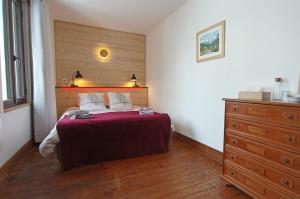 - une chambre avec un lit et une commode dans l'établissement Les ateliers du Cucheron, à Saint-Pierre-de-Chartreuse