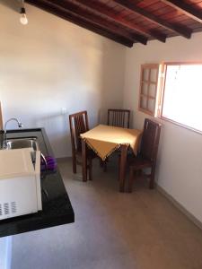 a dining room with a table and chairs and a window at Pousada Pedra Encantada in São Thomé das Letras