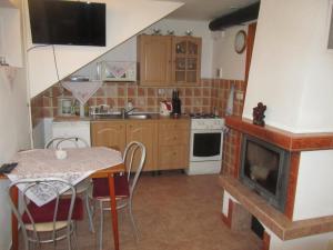 a small kitchen with a table and a fireplace at Privát Sokolie in Terchová