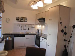 a kitchen with white cabinets and a black counter top at Rosenhof12 in Büsumer Deichhausen