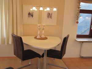 a dining room table with chairs and a lamp at Rosenhof12 in Büsumer Deichhausen
