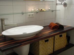 a bathroom with a white sink on a wooden counter at Rosenhof12 in Büsumer Deichhausen