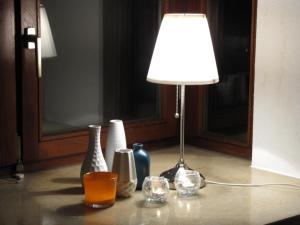 una lámpara sentada sobre una mesa con jarrones en Rosenhof12, en Büsumer Deichhausen
