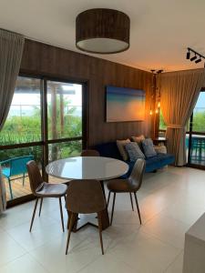 a living room with a table and chairs and a couch at CASA Beira Mar Pé na Areia - Itacimirim Bahia in Camaçari