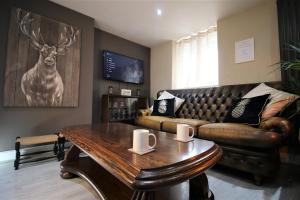 a living room with a couch and a coffee table at Stylish Loft Apartment by Property Promise in Cardiff