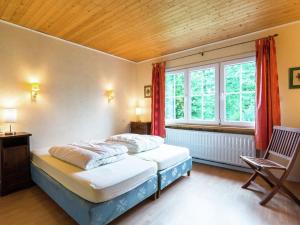 - une chambre avec 2 lits et une fenêtre dans l'établissement Detached chalet with views of the lake of Butgenbach in the middle of nature, à Butgenbach