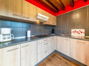 uma cozinha com armários de madeira, um lavatório e um micro-ondas em Lovely Holiday Home in Ardennes Luxembourg em La-Roche-en-Ardenne