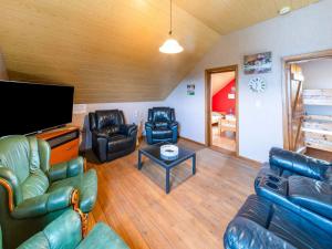 uma sala de estar com mobiliário de couro e uma televisão de ecrã plano em Lovely Holiday Home in Ardennes Luxembourg em La-Roche-en-Ardenne