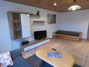 uma sala de estar com um sofá e uma mesa em Quiet apartment along a stream in Halenfeld em Sellerich