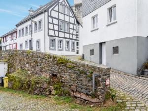 an old stone wall in front of two buildings at Apartment in Hellenthal Reifferscheid with Wellness Oasis in Hellenthal