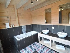 a bathroom with two sinks and a bath tub at Sumptuous Chalet in Septon with Sauna bubblebath in Septon