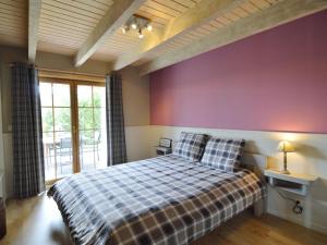 a bedroom with a bed with a purple wall at Sumptuous Chalet in Septon with Sauna bubblebath in Septon