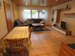 uma sala de estar com uma mesa e um sofá em Quiet apartment along a stream in Halenfeld em Sellerich