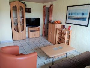 a living room with a couch a table and a tv at Apartment in Leudersdorf Eifel with terrace in Üxheim