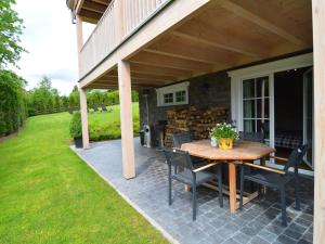 a patio with a table and chairs under a roof at Sumptuous Chalet in Septon with Sauna bubblebath in Septon