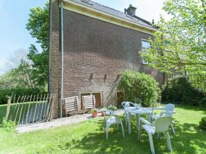 una mesa y sillas en el patio de una casa en Charming house in Easterlittens on a Frisian farm, en Wommels