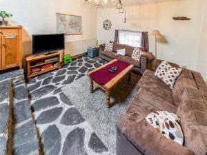 a living room with a couch and a tv at Characteristic holiday home in Cherain with balcony in Cherain