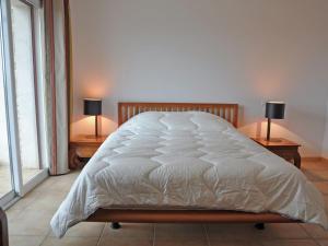 a bed in a bedroom with two lamps on tables at Holiday home with views and private pool in Saint-Victor-de-Malcap