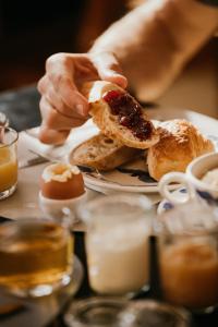 uma pessoa a comer um pedaço de pão num prato em Hotel Spa Azteca Barcelonnette em Barcelonnette