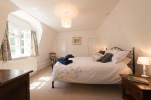 a bedroom with a bed and a desk and a window at The Wobbin, Remote, Comfort, Sea Views and the beautiful Essex Marshes in West Mersea