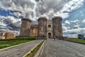 a castle with two towers on a cloudy sky at Napoli Cityscape in Naples