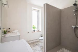 a white bathroom with a toilet and a window at Gare - Redline - Centre Ville in Colmar