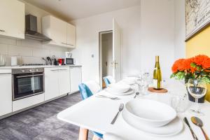 a white kitchen with a white table and chairs at Gare - Redline - Centre Ville in Colmar