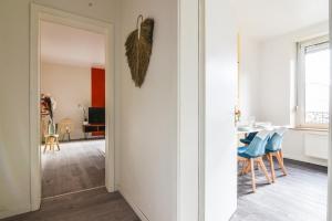 a dining room with a table and blue chairs at Gare - Redline - Centre Ville in Colmar +19 photos