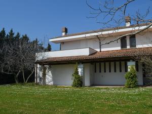 uma casa branca com um grande quintal em frente em Belvilla by OYO Villa degli Ulivi em Vergiano
