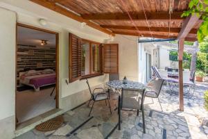 a patio with a table and chairs and a bed at Crikvenica Apartment 89 in Dramalj