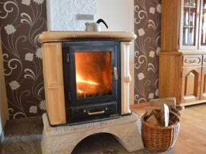 a wood burning stove in a room with a wall at Luxurious farmhouse near the ski area in Hellenthal