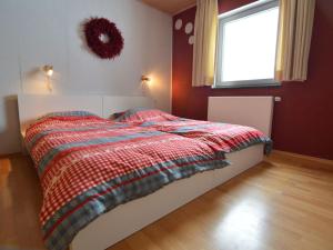 a bedroom with a bed with a checkered blanket at Luxurious farmhouse near the ski area in Hellenthal