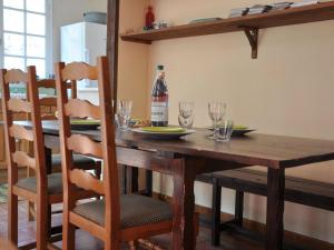 a wooden table with a bottle of wine and glasses at Chalet with garden in the Pyrenees in Roquefort-de-Sault
