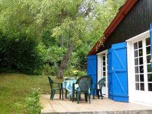 a table and chairs on a patio with a house at Chalet with garden in the Pyrenees in Roquefort-de-Sault