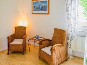two wicker chairs and a table in a room at Modernes Familienapartment in Medebach