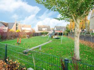 een park met een speeltuin met een boom en een schommel bij Holiday home near the Frisian Eleven Cities in Mantgum