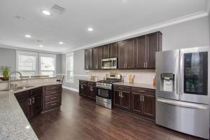 a kitchen with wooden cabinets and a stainless steel refrigerator at !!!KATY TEXAS GETaWAY!!! in Katy