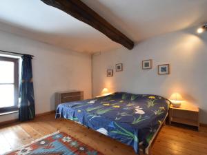 Authentic cottage nearby a beautiful forest في Lierneux: غرفة نوم بسرير لحاف ازرق ونافذة