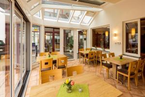 um restaurante com mesas, cadeiras e janelas em Landhotel Wolf-Mertes em Sessenbach