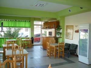 a restaurant with tables and chairs and a kitchen at Apart Hotel Alem in Ushuaia