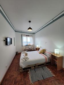 a bedroom with a large bed and a table at The Handmade House Azores in Porto Formoso